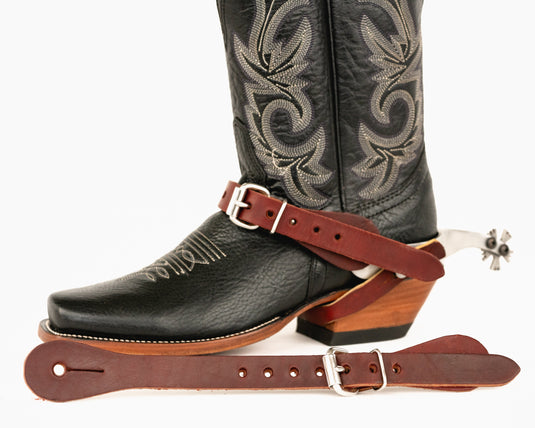 A brown leather spur strap with a metal buckle.